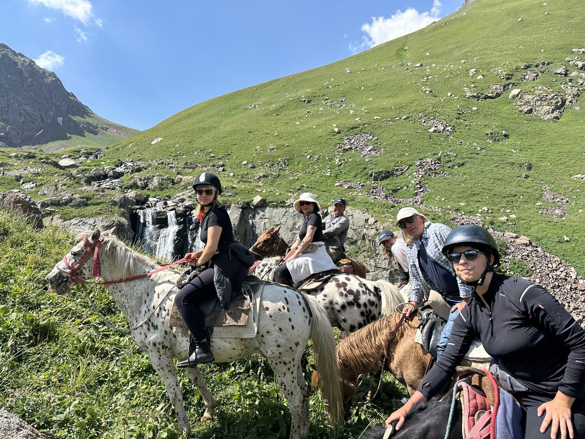 Groupe de cavaliers devant une cascade, randonnée à cheval Kirghizistan